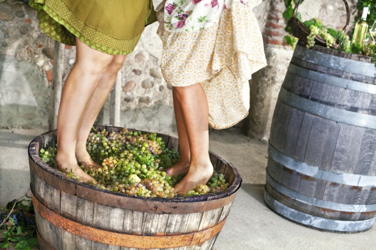 women pounding grapes